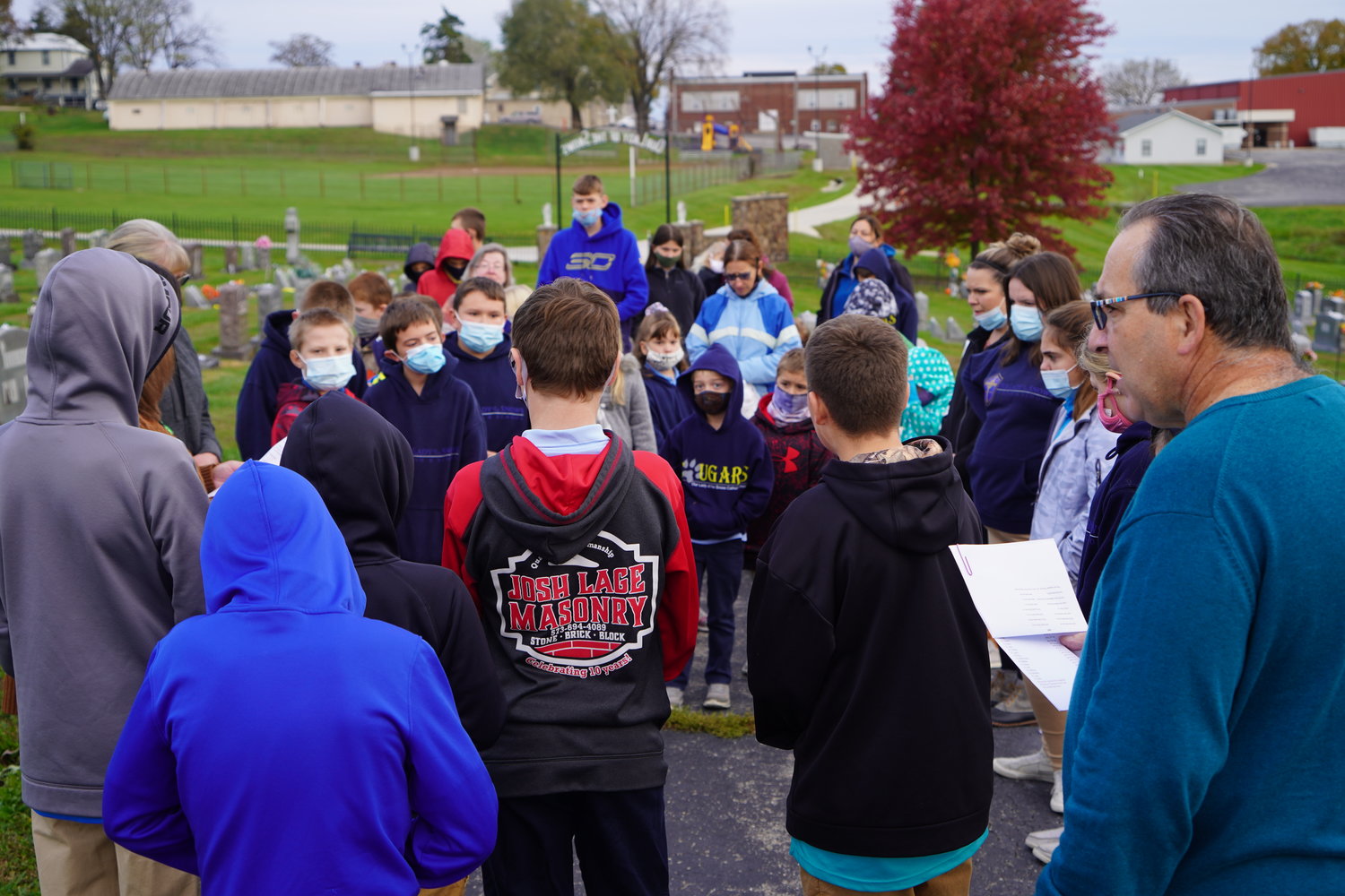 Students of Our Lady of the Snows School pray for the faithful departed in their parish cemetery Nov. 2.